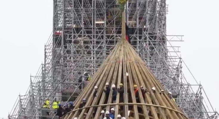 Aufrichte - der Notre Dame Paris Dachstuhl ist fertig gebaut, Bauarbeiter winken